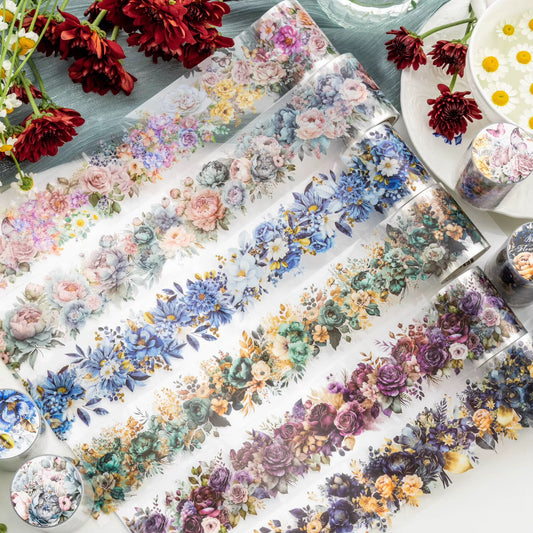 Collection of floral-themed tape rolls on a white surface with additional flowers and containers.