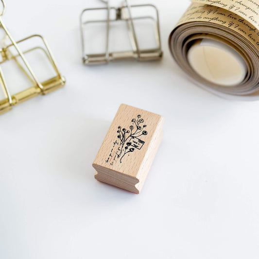Mini wooden flower stamp on table with binder clips in the background