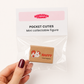 A hand with dark burgundy nail polish holds a clear plastic bag containing a small collectible figure. The packaging card reads 'BUBBLEGUM FRINGE' and 'POCKET CUTIES Mini collectable figure'.