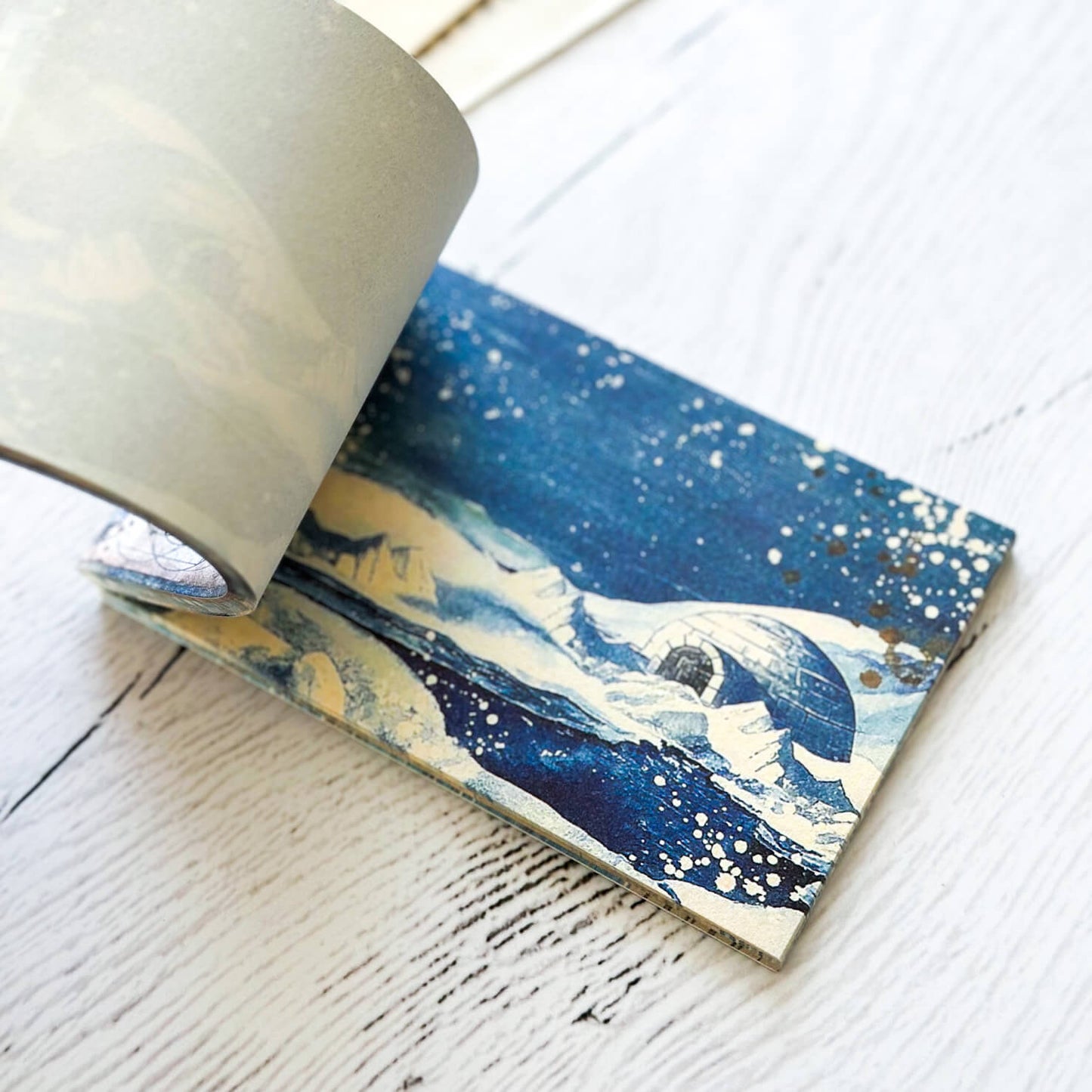 Decorative paper that has a North pole scene with iglo and icebergs.
